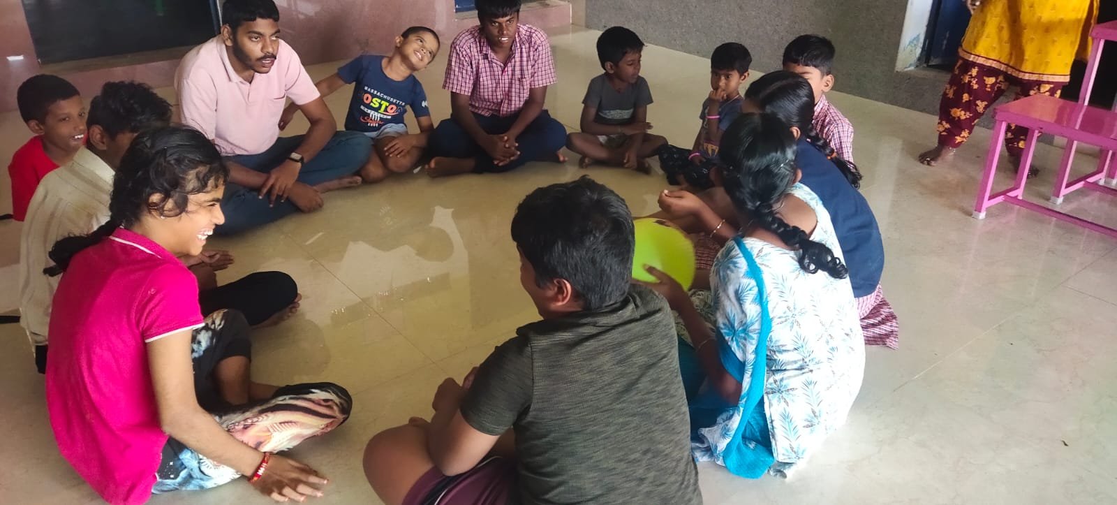 Group circle activity with children and volunteers